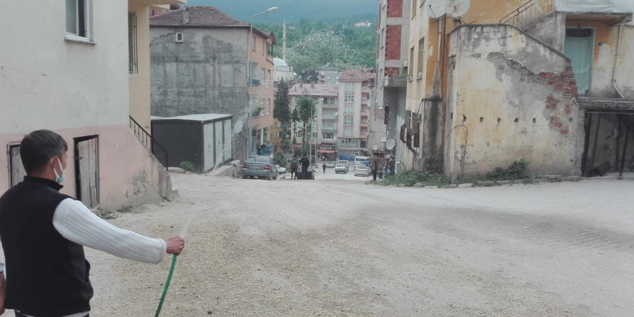 Tozdan bunalan esnaf, çareyi yolu sulamakta buldu