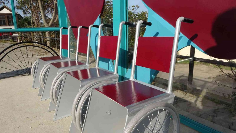 TRABZON BÜYÜKŞEHİR BELEDİYESİ TARAFINDAN DURAKLARA DİZAYN EDİLEN TEKERLEKLİ SANDALYE GÖRÜNÜMÜNDEKİ OTURAKLAR DİKKAT ÇEKERKEN, OTURAKLARI GÖRENLER DÖNÜP BİR DAHA BAKIYOR