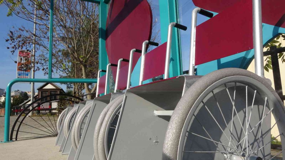 TRABZON BÜYÜKŞEHİR BELEDİYESİ TARAFINDAN DURAKLARA DİZAYN EDİLEN TEKERLEKLİ SANDALYE GÖRÜNÜMÜNDEKİ OTURAKLAR DİKKAT ÇEKERKEN, OTURAKLARI GÖRENLER DÖNÜP BİR DAHA BAKIYOR