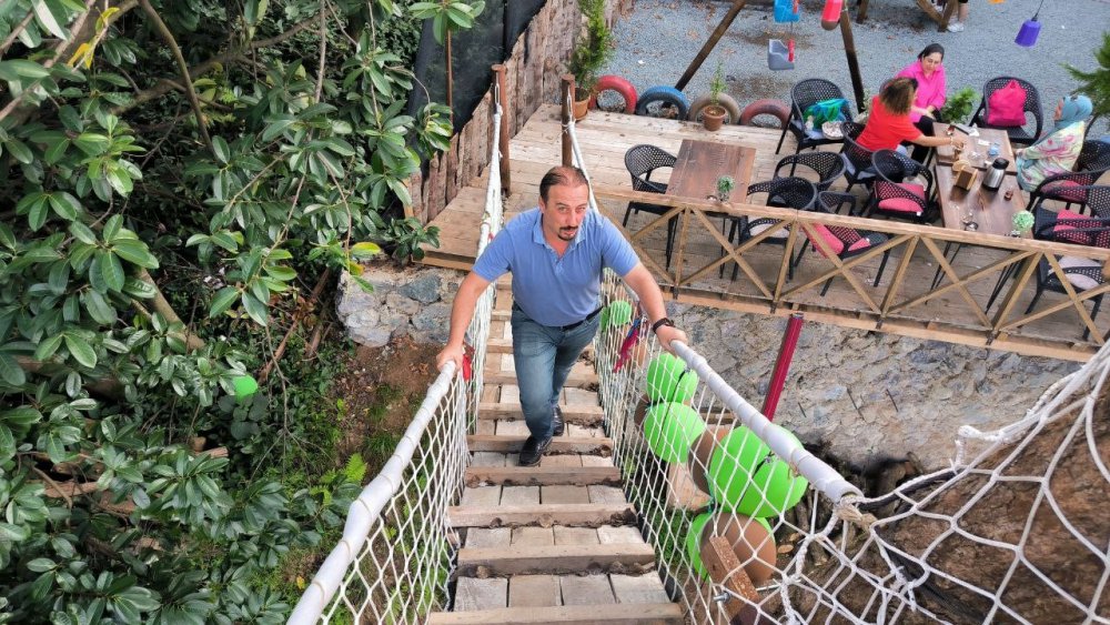 ARTVİN'İN ARHAVİ’DE YAŞAYAN 43 YAŞINDAKİ SELAHATTİN ALKAN HAYALİNİ KURDUĞU RESTORANI İÇİN ARAZİSİNDE BULUNAN AĞAÇLARI KESMEYE KIYAMAYINCA AĞAÇLARIN ÜZERİNE BARAKA VE KAMELYA YAPARAK KÖPRÜ EŞLİĞİNDE RESTORANINA DAHİL ETTİ