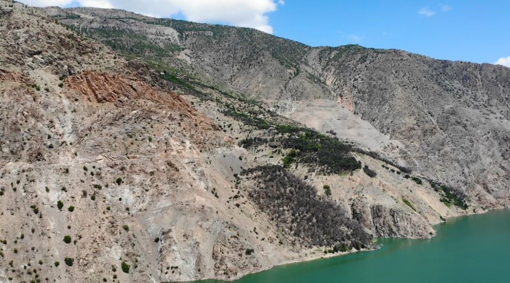 Artvin'de kapalı olan köy yolunu kepçe yardımıyla geçiyorlar